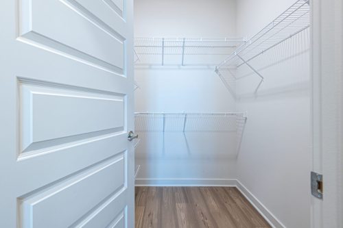 Apartments For Rent Downtown Knoxville Open door reveals an empty walk-in closet with white wire shelving on two walls and light wood flooring. Knoxville Apartments
